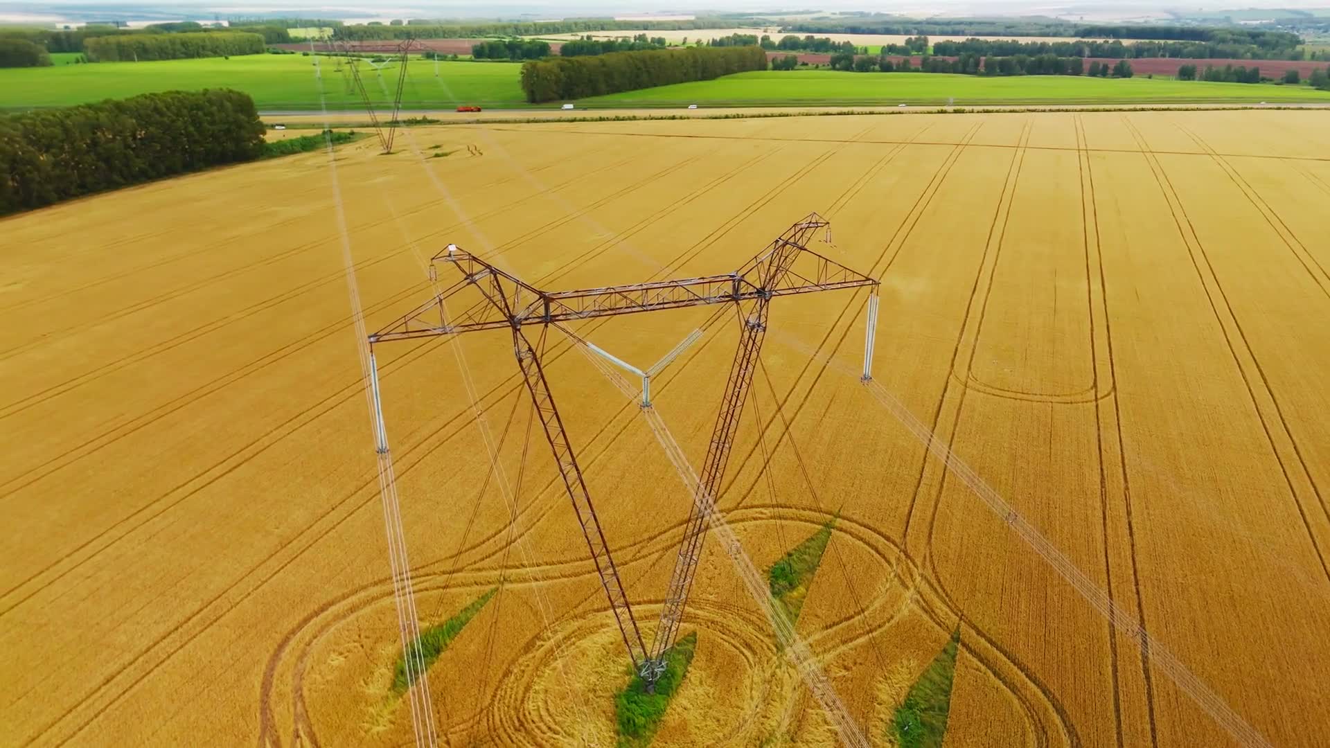 Linie wysokiego napięcia nad złocistym polem zboża